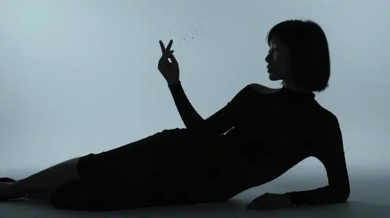 A slouched silhouette with crossed arms floats in blue mist