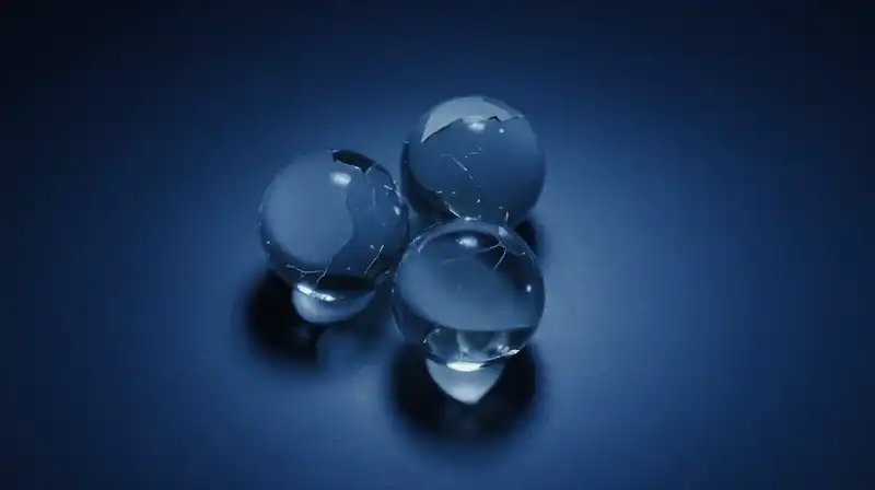 Three fractured glass spheres float in a deep blue void