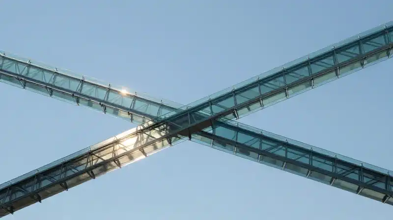Two glowing and shadowed glass bridges intersect in blue space